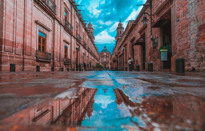 Cathedral Reflected in Puddle on Historic Street