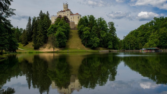 Trakoscan Castle reflected in a lake surrounded by trees
