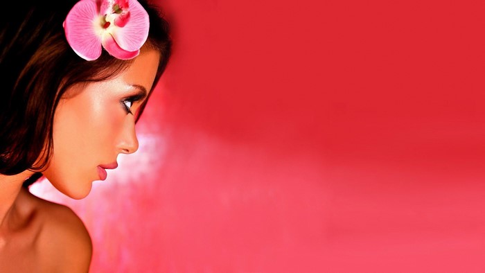Woman with pink orchid in hair