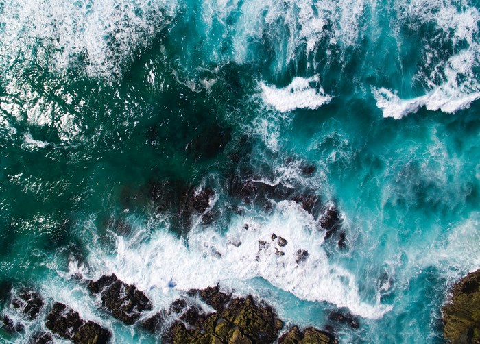 Aerial view of ocean waves crashing on rocks in Australia
