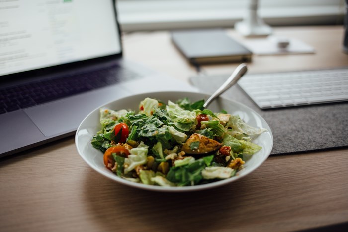 Salad and laptop on a desk