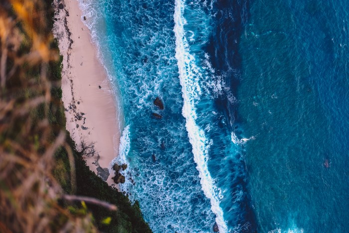 Aerial view of a sandy beach with turquoise ocean waves