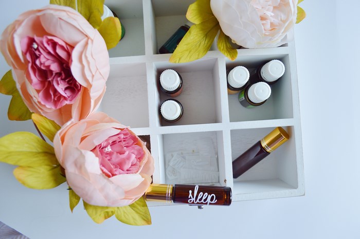 Essential oils in a wooden organizer with flowers