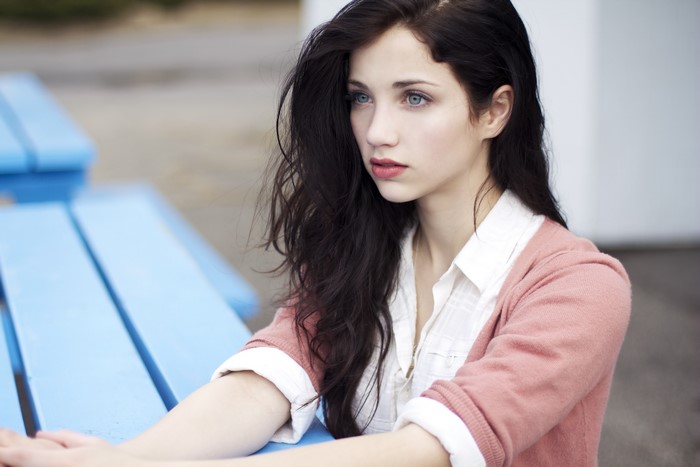 Brunette woman with blue eyes sitting at a picnic table