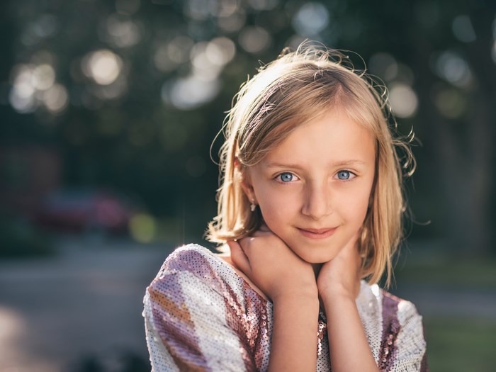 Blonde Young Girl with Blue Eyes in Soft Summer Light