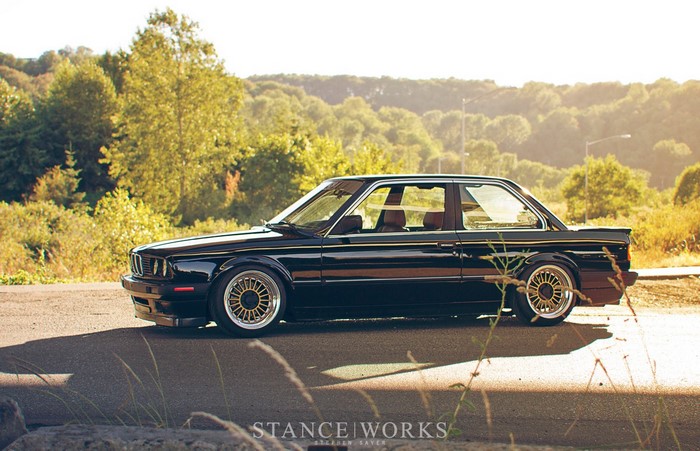 Black BMW E30 parked on a road