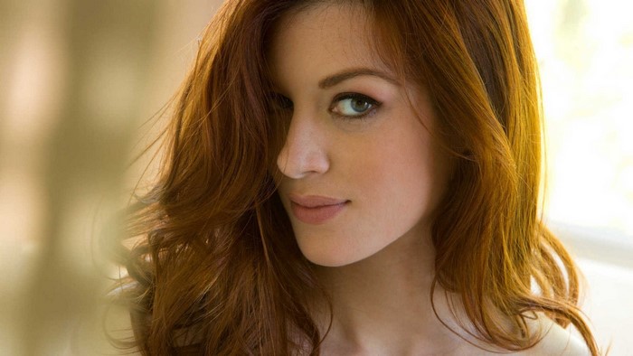 Redhead woman with green eyes, face closeup