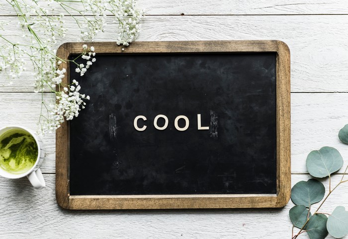 Black chalkboard with the word COOL and a cup of matcha