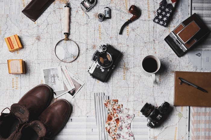 Vintage travel planning with cameras, map, and boots