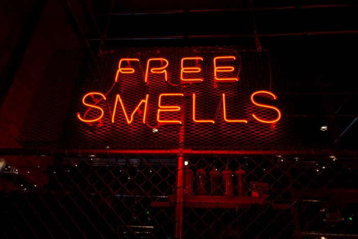 Red neon sign with words FREE SMELLS