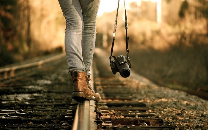 Woman with Canon camera walking on train tracks