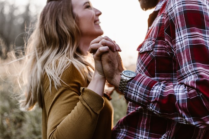 Couple holding hands and laughing outdoors