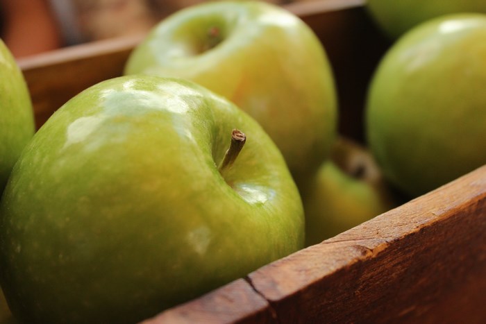 Green apples in a wooden crate