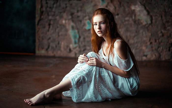Redhead woman sitting on floor