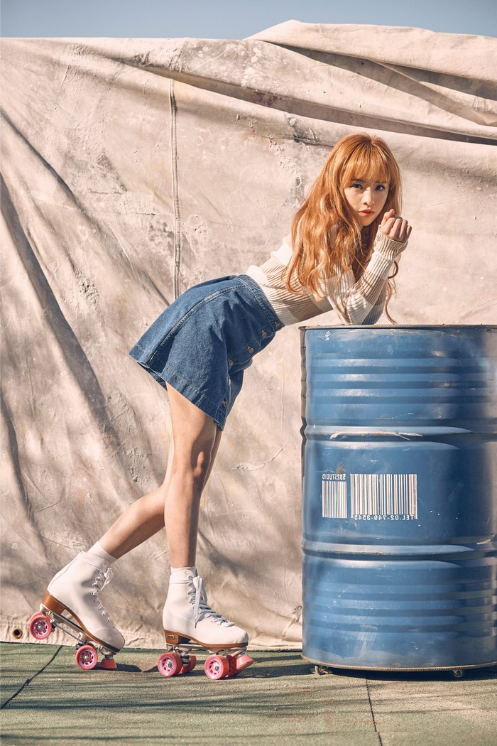 Woman with red hair wearing roller skates and denim skirt