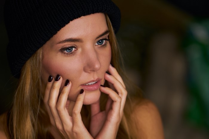 Woman with blonde hair wearing a black beanie