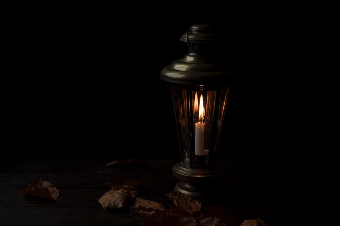 Lantern with candle light and autumn leaves