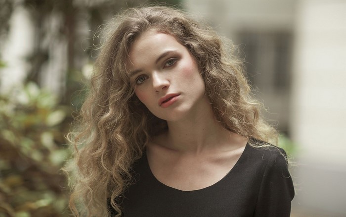 Woman with curly hair looking at viewer