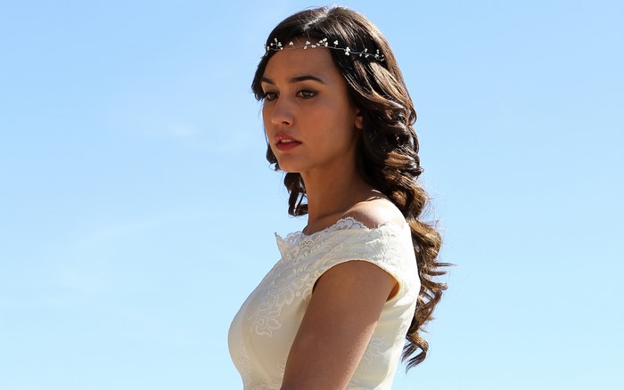 Megan Montaner wearing a white dress and headpiece