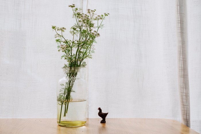 Still life with flowers and a small chicken figurine