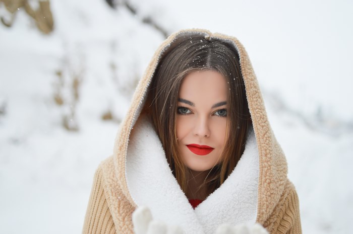 Woman in hooded sweater in the snow