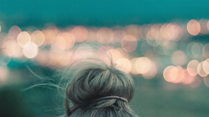 Woman with hair bun and bokeh lights background
