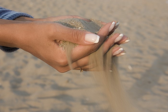 Woman's hands holding sand