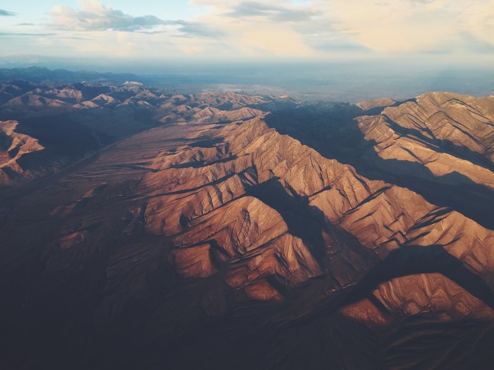 Aerial view of a vast mountain range at sunset