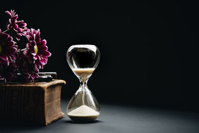 Hourglass with Old Book and Purple Flowers