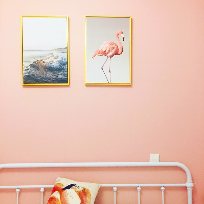 Pink flamingo and ocean wave art on pink wall