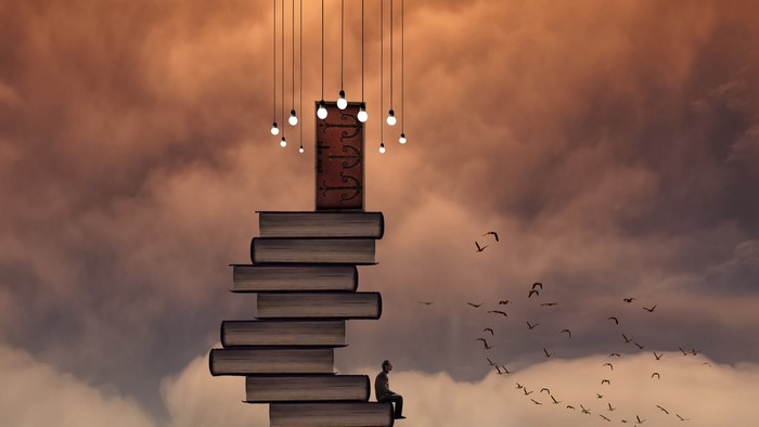 Man sitting on books leading to a door with lights