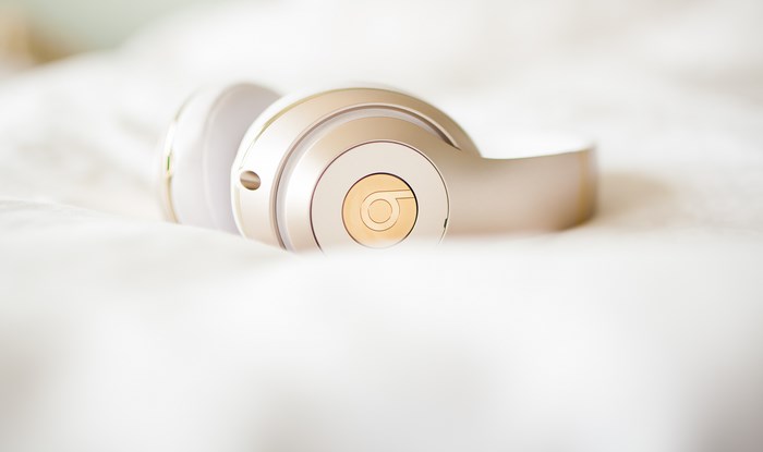 Gold and white Beats headphones on a white surface