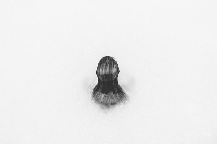 Woman submerged in white water, black and white