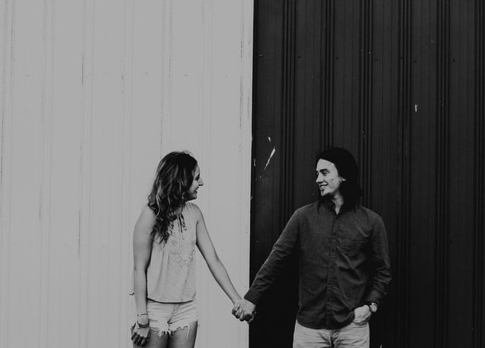 Couple holding hands in front of a color block wall