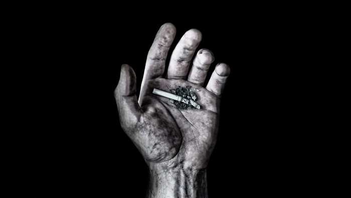 Hand holding a cigarette butt