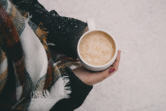 Woman holding a cup of latte in winter