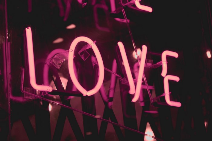 Pink neon sign spelling "LOVE" at night