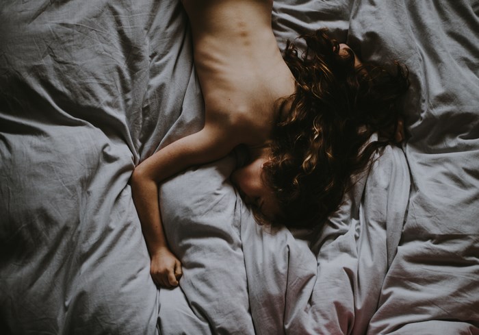 Child Resting on Bed with White Sheets
