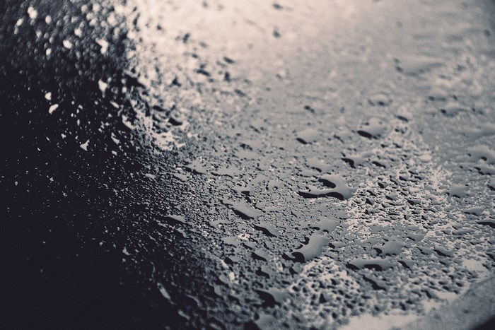 Close-up of water droplets on a dark surface