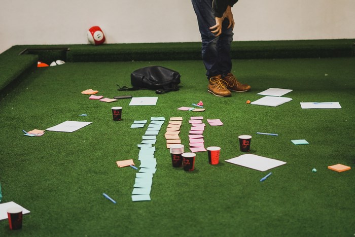 People planning with sticky notes on a pool table