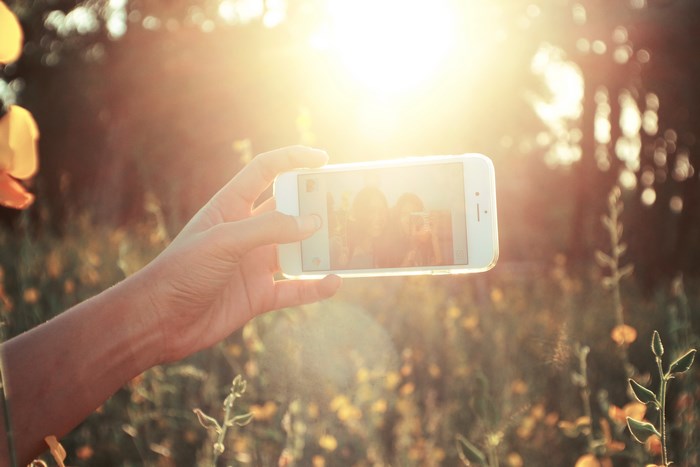 iPhone selfie in a sunlit meadow
