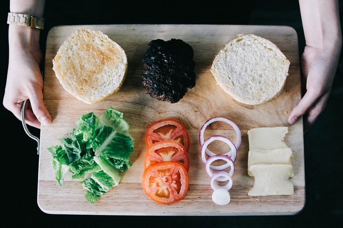 Burger ingredients on a wooden chopping board