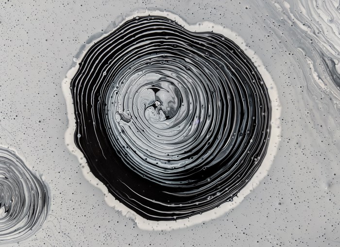 Abstract acrylic black paint swirls in water on white background