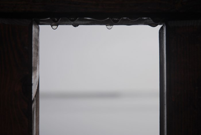 Raindrops on a wooden frame against a light background