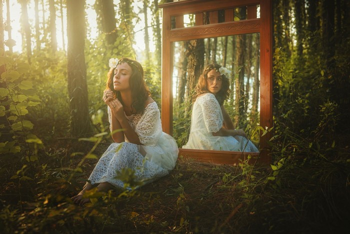 Woman in White Dress Sitting Next to Mirror in Forest