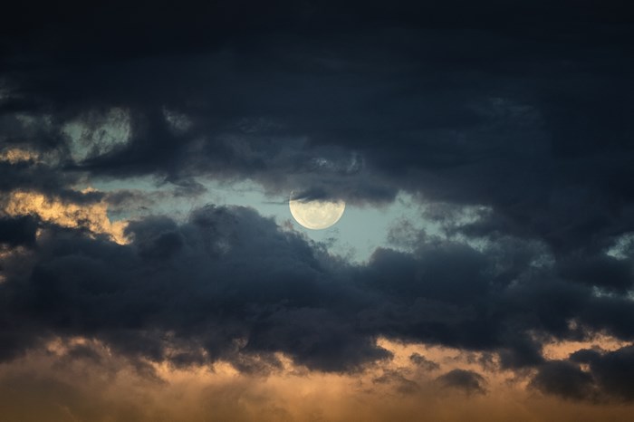 Full Moon Hidden Behind Dark Clouds at Dusk