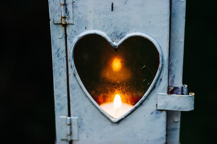 Candle burning inside a heart-shaped lantern