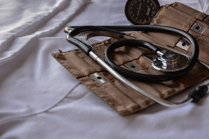 Stethoscope and blood pressure cuff on white fabric