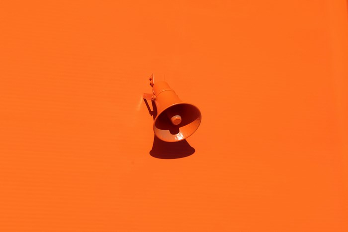 Orange megaphone mounted on an orange wall