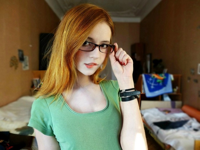 Redhead woman with glasses biting lip